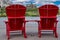 Red adirondack chairs defocused at Waterton Lakes National Park, in Canada during summer