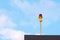 Red aircraft warning lights with blue sky background at roof of high rise building