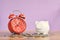 Red alarm clock coin and piggy bank