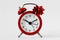 Red alarm clock with gift bow on white background - The gift of time concept; time for gift giving concept