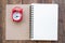 The red alarm clock placed on the cover of the address book for recording. Time management concepts Writing notes at important