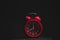 Red alarm clock showing eight clock, black background