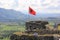 Red Albanian flag with a double-headed black eagle waving over the top of old fortress Rozafa