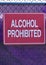 Red alcohol prohibited sign against a purple tennis net