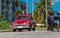 Red american classic car parked on the street in Varadero Cuba with a carriage