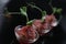 Red appetizing Tartar sauce in three pialas, decorated with a stem of sprouted green peas, close-up