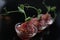 Red appetizing Tartar sauce in three pialas, decorated with a stem of sprouted green peas, close-up