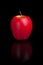 Red apple on a black reflective background