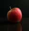 Red Apple on black reflective surface