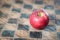 Red apple on a checked wooden board, concept