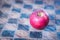 Red apple on a checked wooden board, concept