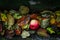 Red apple fallen from tree laying among autumn leaves on the ground