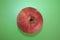 Red apple on a green background, a motive and color game, an odd motif