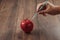 Red apple injecting a needle or syringe and chemical pesticides on a wooden background. Specific pesticide residues in apples,