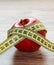 A red Apple is measured by a meter. Slimness and diet