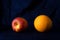 Red apple and orange classical still life food fruit with dark silk blue fabric background