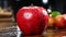 A red apple sits on a wooden table