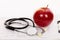 Red apple and stethoscope on an electrocardiogram (ECG) chart