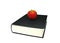 Red apple on top of black hard-cover dictionary book isolated on white background.