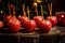 Red apples covered with caramelized sugar. Apples on sticks as traditional Christmas dessert on a backdrop on Christmas tree