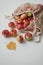 Red apples in a eco mesh shopping bag on a white background. Zero waste, no plastic. Autumn flatlay