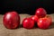 Red apples lie on a burlap covered table