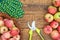 Red apples on old wooden boards with garden gloves and pruner