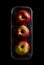 Red apples are placed in a stainless steel rectangle basket on a black background, top view.