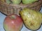 Red apples and yellow pears in a wicker basket. Autumn harvest. Natural and environmentally friendly fruits.