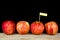 Red apples and yollow label put on wooden with black background