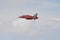 Red Arrow in flight trailing white smoke