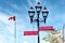 Red arrow street signs mounted on a lamp post with canadian flag in Montreal, Quebec, Canada