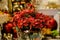 Red artificial poinsettia flowers decorated with silver tinsel in a golden vase