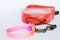 Red automatic leash and pink nylon pet collar on white background