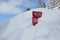 Red Avalanche Warning Sign Buried in Snow