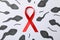 Red awareness ribbon and sperm cells on white background