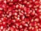 Red Background of Grain Red Grenades. Big Ripe Red Granets or Garnets. Fruits of Red Ripe Pomegranate on the White