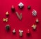 On red background a layout of Christmas ornaments gift bows of nuts and cones in the form of hours that are thrown 12