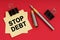 On a red background, a pen and stickers with the inscription - Stop Debt