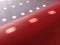 Red background with polka dots. Rays of the sun shining through the holes in the blinds and painting light blurry circles on the