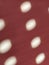 Red background with polka dots. Rays of the sun shining through the holes in the blinds and painting light blurry circles on the