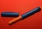 On a red background, a syringe pen for the introduction of insulin to a patient with diabetes, endocrinological diseases