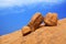 Red bald granite peak, blue sky, white cloud background, three round ancient orange stones, natural yellow rock, Swakopmund