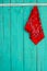 Red bandana hanging by rope border on antique blue wooden background