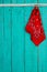 Red bandana and key hanging by rope on antique teal blue background