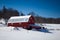 Red barn in Canaan Valley West Virginia surrounded by snow under a clear blue sky