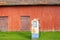 Red barn in the country with an old rusty petrol pump