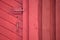 Red barn door with handle and key hole and deadbolt lock