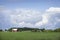 Red barn and field below dramatic cloudscape