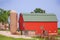 A red barn with a green roof and silo in rural Wisconsin.